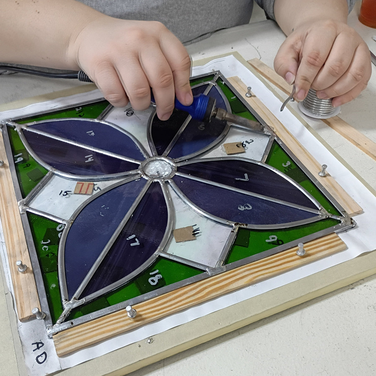 person soldering a lead came panel