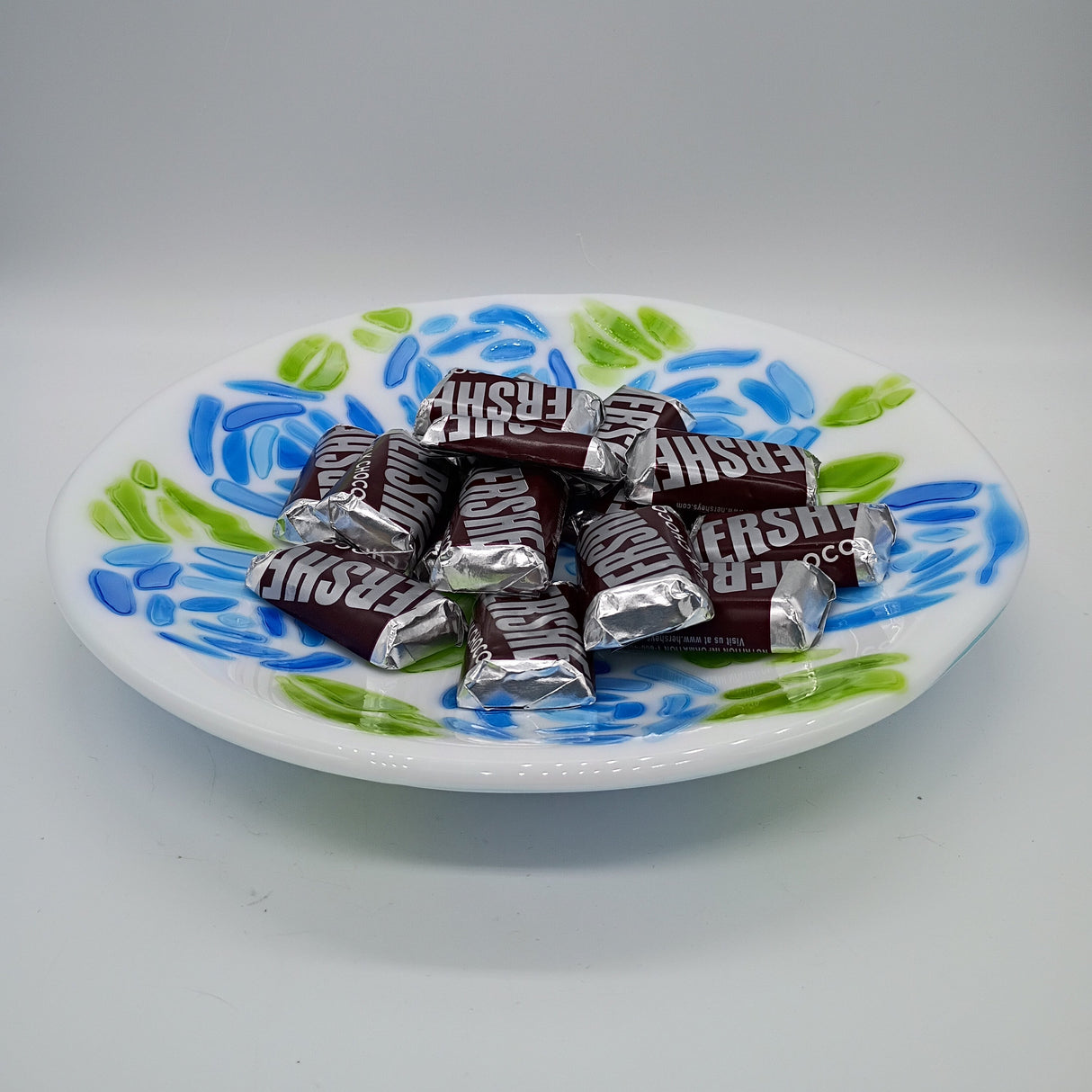 Assorted Hershey's chocolate bars on a decorative plate with floral patterns