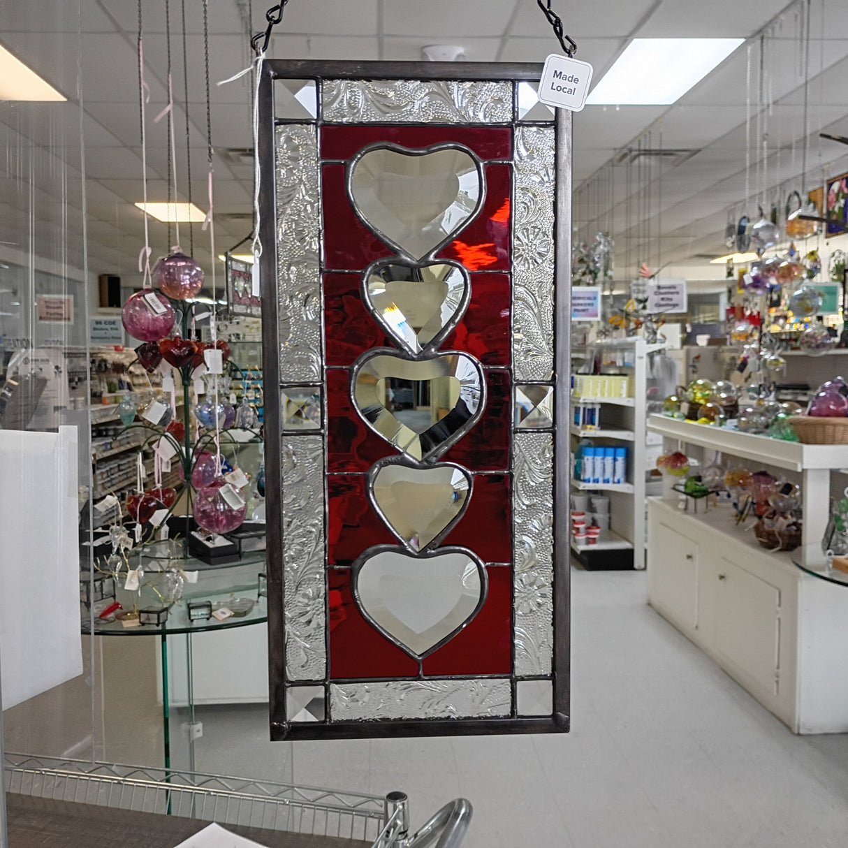 Decorative stained glass panel with heart designs in a store setting