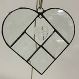 Heart-shaped decorative hanging with clear heart in center on white background