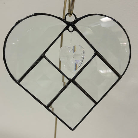 Heart-shaped decorative hanging with clear heart in center on white background