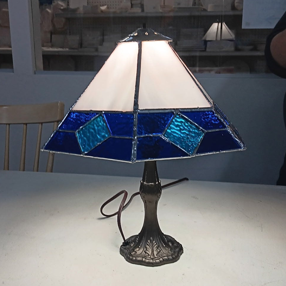 Tiffany-style lamp with stained glass shade on a white surface