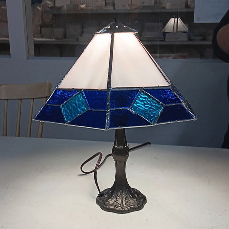 Tiffany-style lamp with stained glass shade on a white surface