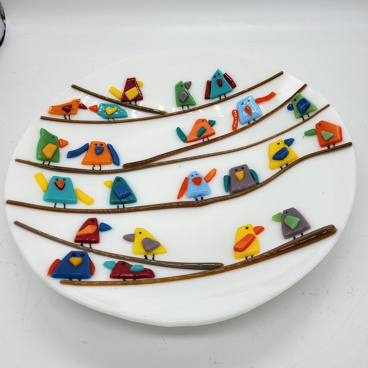 white fused glass plate decorated with multicolored birds