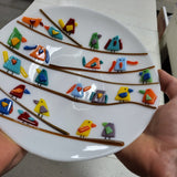 white fused glass plate with multicolored birds closeup