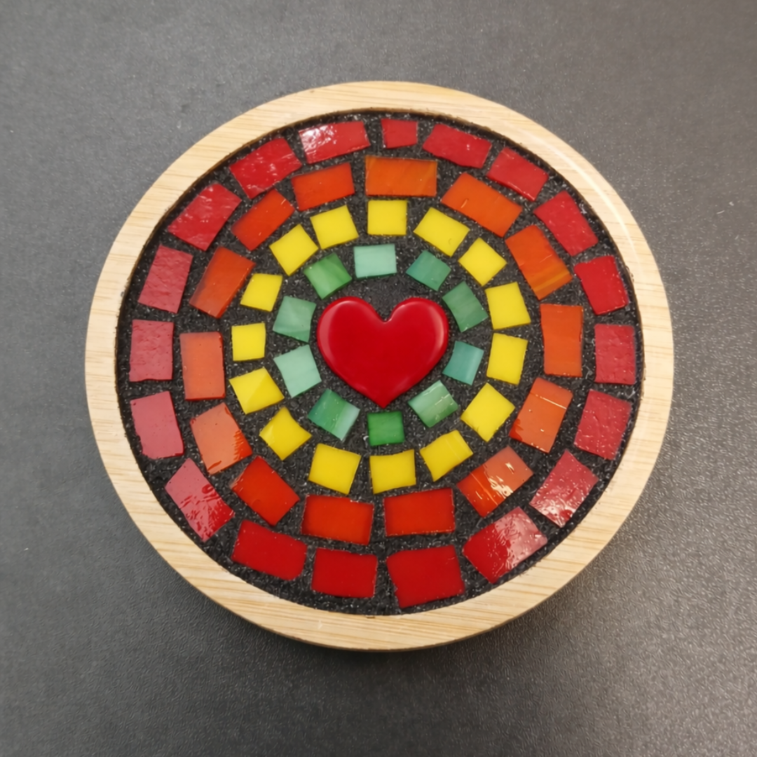 Round mosaic coaster with a red heart in the center on a dark gray background