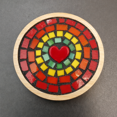 Round mosaic coaster with a red heart in the center on a dark gray background