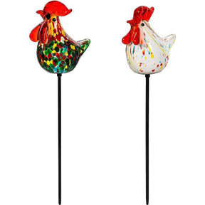 Two colorful glass rooster garden stakes on white background
