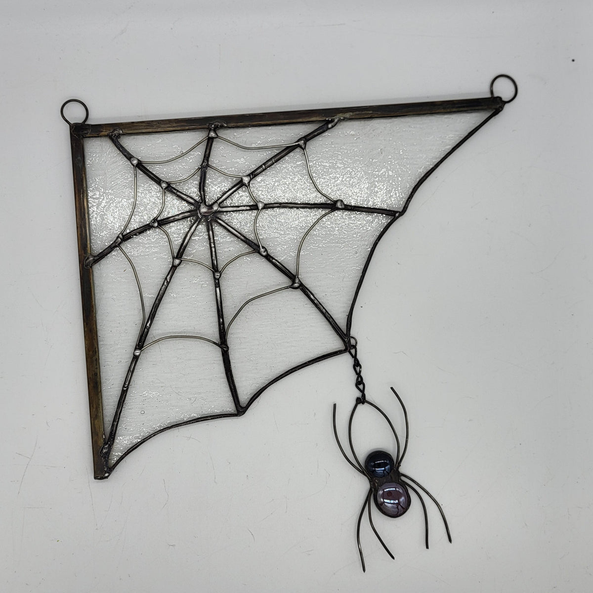 stained glass spiderweb with clear textured glass and a black spider