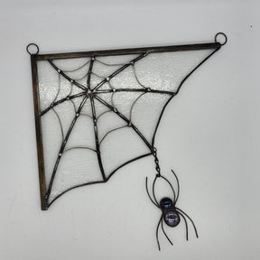 stained glass spiderweb with clear textured glass and a black spider