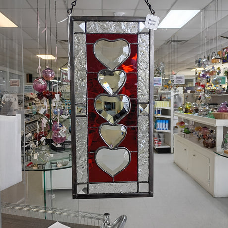 Decorative stained glass panel with heart designs in a store setting